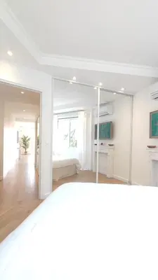 a white living room with a large glass wall at La Dolce Vita de Cannes: Luxury city center apartement, beautiful View in Cannes