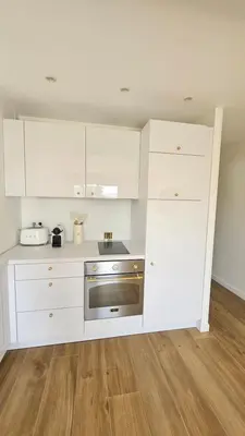 a kitchen with white cabinets and a stainless steel oven at La Dolce Vita de Cannes: Luxury city center apartement, beautiful View in Cannes