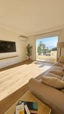 a living room with a couch and a large window at La Dolce Vita de Cannes: Luxury city center apartement, beautiful View in Cannes