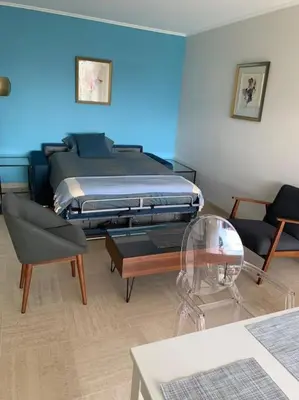 a room with a bed and a table and chairs at Croisette and beaches. View on gardens and sea. in Cannes