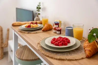 a table with plates of fruit and croissants and orange juice at Studio Banane 2 min croisette mitoyen Martinez in Cannes