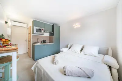 a small room with a bed and a kitchen at Studio Banane 2 min croisette mitoyen Martinez in Cannes