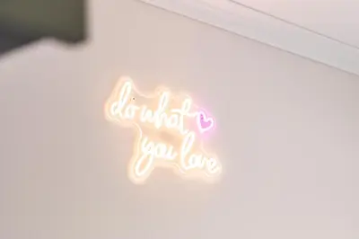 a neon sign that reads what you love at Studio Banane 2 min croisette mitoyen Martinez in Cannes
