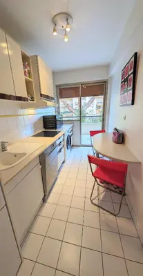 a kitchen with a table and a red chair at LACOUR7 Palmes dProperties in Cannes
