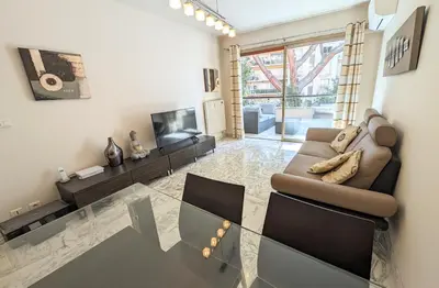 a living room with a couch and a television at LACOUR7 Palmes dProperties in Cannes