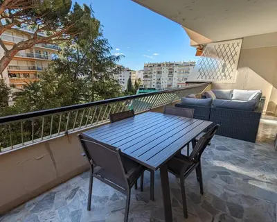 a blue table and chairs on a balcony with a couch at LACOUR7 Palmes dProperties in Cannes