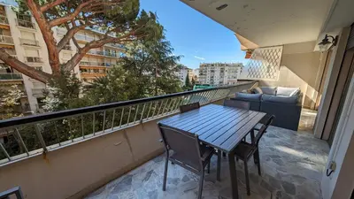 a table and chairs on a balcony with a couch at LACOUR7 Palmes dProperties in Cannes