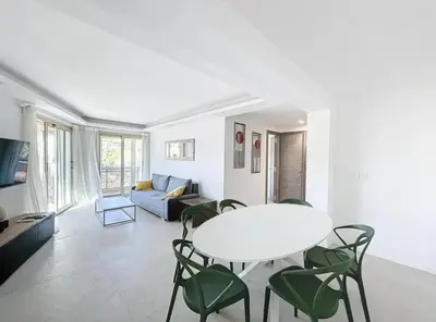 a living room with a table and chairs and a couch at Modern 2 Bedroom in the Heart of Cannes in Cannes