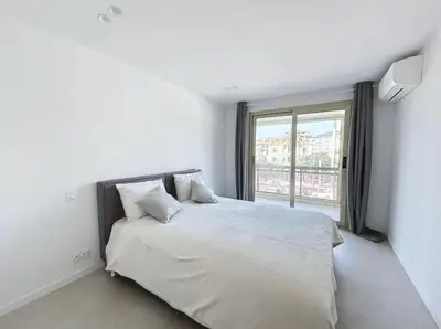 a bedroom with a white bed with a large window at Modern 2 Bedroom in the Heart of Cannes in Cannes