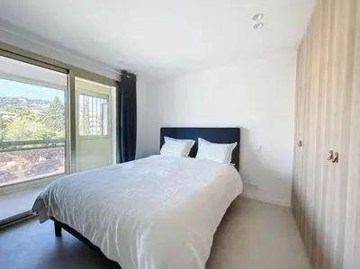 a bedroom with a large bed with a large window at Modern 2 Bedroom in the Heart of Cannes in Cannes