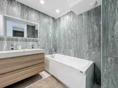 a bathroom with a white tub and a sink at Modern 2 Bedroom in the Heart of Cannes in Cannes