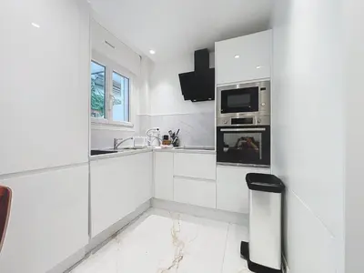 a white kitchen with a sink and a microwave at Résidence Lacour in Cannes