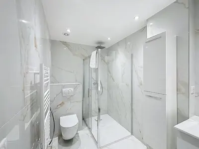 a white bathroom with a shower and a toilet at Résidence Lacour in Cannes