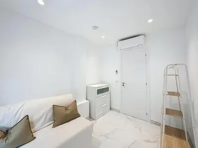 a living room with a white couch and a ladder at Résidence Lacour in Cannes