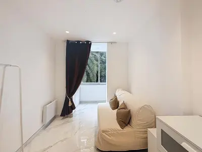 a living room with a couch and a window at Résidence Lacour in Cannes