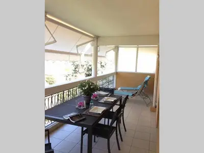 a dining room with a table and chairs on a balcony at Hibiscus in Cannes