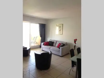 a living room with a couch and a table at Hibiscus in Cannes