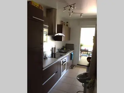 a kitchen with a black refrigerator and a sink at Hibiscus in Cannes
