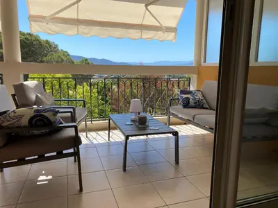a living room with a table and chairs on a balcony at Hibiscus in Cannes