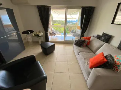 a living room with a couch and a chair at Hibiscus in Cannes