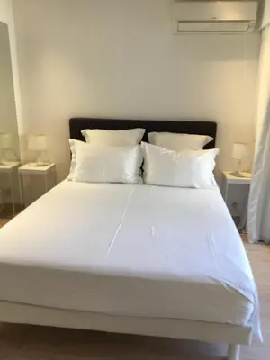 a bed with white sheets and pillows in a room at center of cannes in Cannes