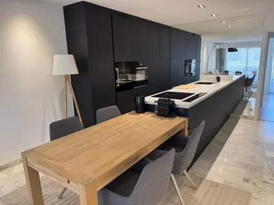 a kitchen with a wooden table and black cabinets at center of cannes in Cannes