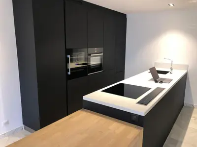 a kitchen with black cabinets and a white counter at center of cannes in Cannes
