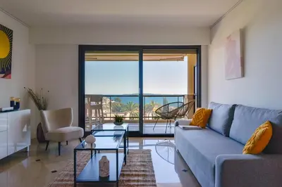 a living room with a couch and a view of the ocean at 1-Br apartment calm sea view pool and parking garage in Cannes