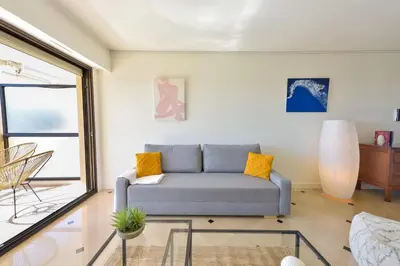 a living room with a couch and a glass table at 1-Br apartment calm sea view pool and parking garage in Cannes