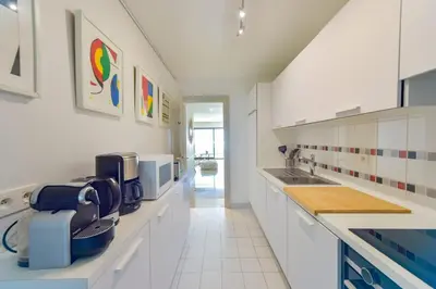 a kitchen with white cabinets and a sink at 1-Br apartment calm sea view pool and parking garage in Cannes