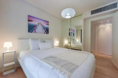 a bedroom with a large white bed and a mirror at 1-Br apartment calm sea view pool and parking garage in Cannes