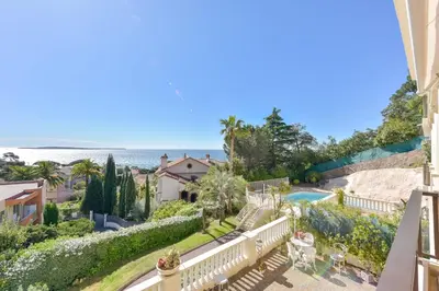 a view of a house and the ocean from a balcony at 1-Br apartment calm sea view pool and parking garage in Cannes