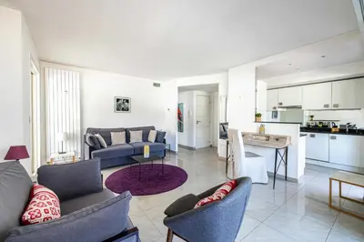 a living room with a couch and a kitchen at Bright apartment near the Croisette - Cannes in Cannes