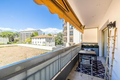 a balcony with a table and chairs on a building at Bright apartment near the Croisette - Cannes in Cannes