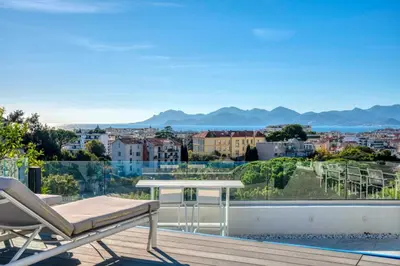 a balcony with a table and a view of a city at Sumptuous terrace apartment - Cannes - Sea view in Cannes