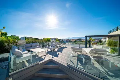 a patio with chairs and tables on a roof at Sumptuous terrace apartment - Cannes - Sea view in Cannes
