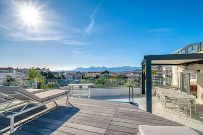 an outdoor deck with chairs and a view of a city at Sumptuous terrace apartment - Cannes - Sea view in Cannes