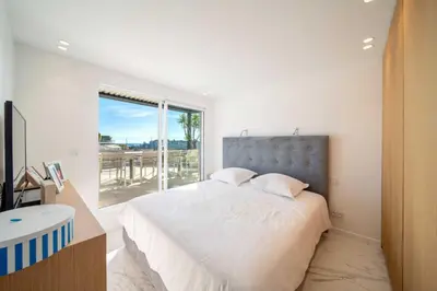 a bedroom with a large bed and a large window at Sumptuous terrace apartment - Cannes - Sea view in Cannes