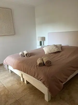 a large bed with three pillows on top of it at Cannes Palm Beach in Cannes