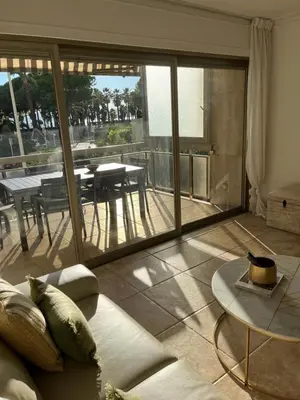 a living room with a view of a balcony with a table at Cannes Palm Beach in Cannes