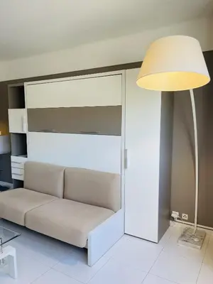 a living room with a couch and a lamp at Studio proche centre FARN4 in Cannes