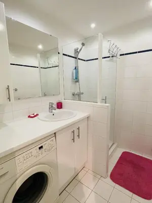 a white bathroom with a sink and a washing machine at Studio proche centre FARN4 in Cannes