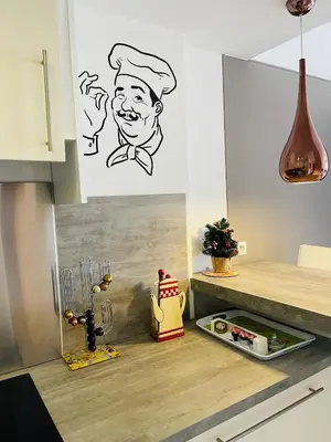 a kitchen with a drawing of a chef on the wall at Studio proche centre FARN4 in Cannes