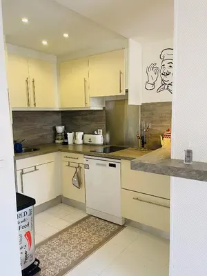 a kitchen with white cabinets and white appliances at Studio proche centre FARN4 in Cannes
