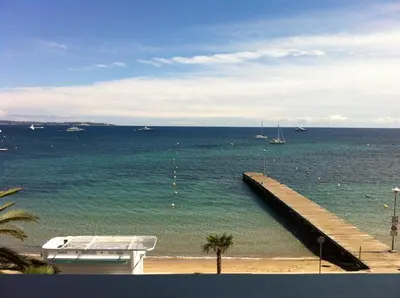 a view of the ocean with a pier and a boat at Studio Cannes bord de mer in Cannes