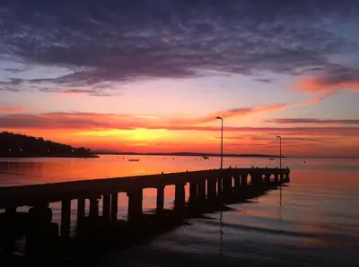 a pier with a sunset over the water at Studio Cannes bord de mer in Cannes