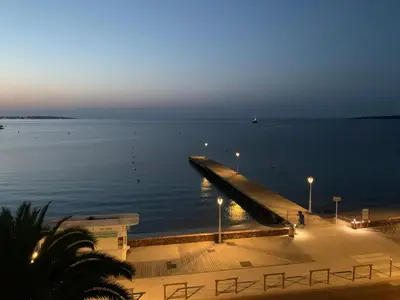 a dock in the middle of the water at night at Studio Cannes bord de mer in Cannes