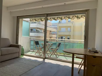 a living room with a view of a balcony at Studio Cannes bord de mer in Cannes