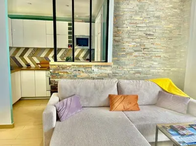 a living room with a couch with two pillows on it at Mérimée in Le Cannet