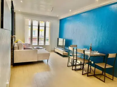 a living room with a couch and a blue wall at Mérimée in Le Cannet